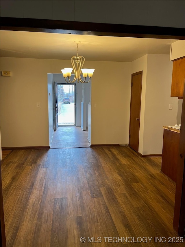 unfurnished dining area with dark hardwood / wood-style flooring and an inviting chandelier