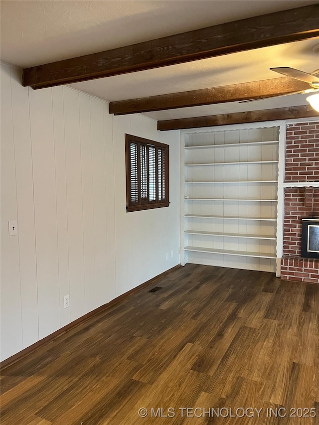 503 Parkview Dr, Bartlesville, OK 74003 - unfurnished living room featuring dark wood-type flooring, beam ceiling, a ceiling fan, and a brick fireplace
