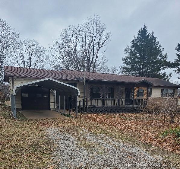 ranch-style home featuring a carport and covered porch