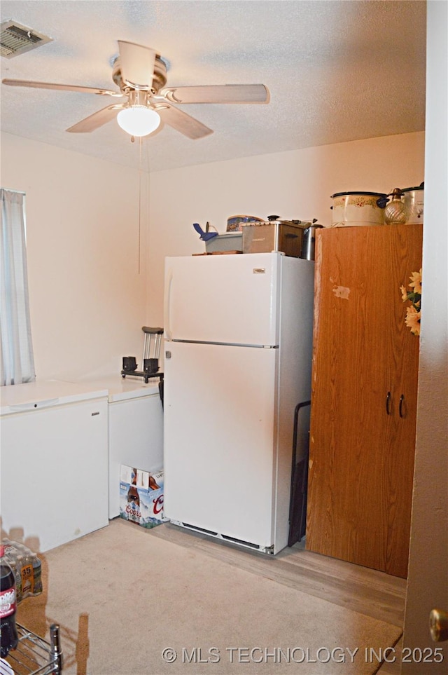 kitchen with refrigerator, ceiling fan, a textured ceiling, and white refrigerator
