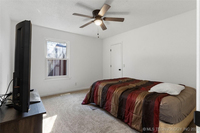 carpeted bedroom with ceiling fan and a textured ceiling