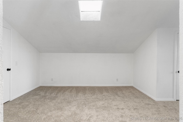 additional living space featuring light carpet, lofted ceiling, and a textured ceiling