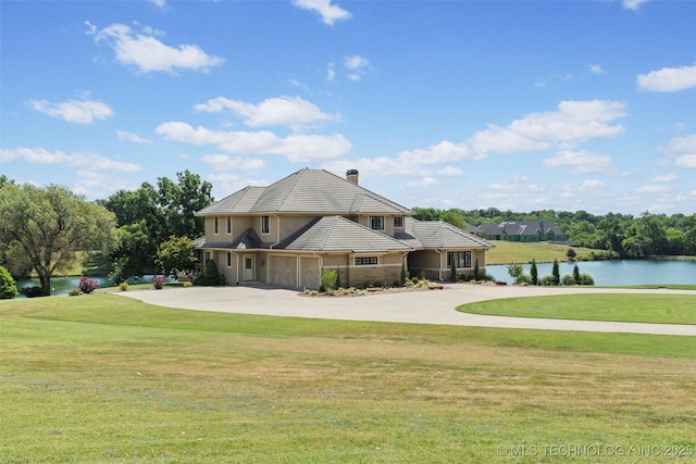 view of front of property featuring a water view, a garage, and a front yard