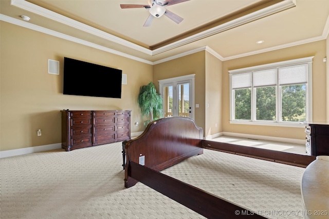 carpeted bedroom with multiple windows, access to exterior, a tray ceiling, and ornamental molding