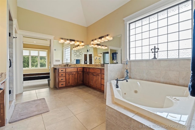 bathroom with vanity, vaulted ceiling, tile patterned floors, and tiled bath