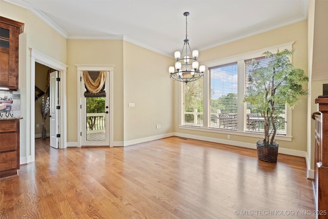 unfurnished dining area featuring crown molding, an inviting chandelier, and light hardwood / wood-style flooring