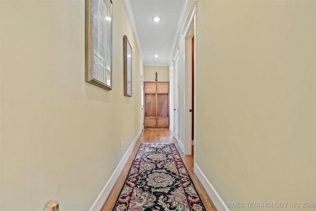 corridor with crown molding and light hardwood / wood-style flooring