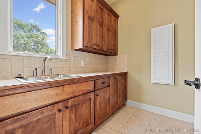 kitchen featuring sink, backsplash, and light tile patterned flooring