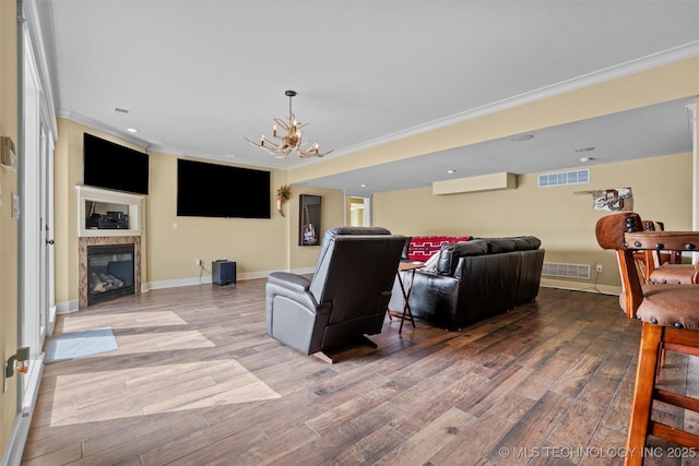 living room with hardwood / wood-style floors, crown molding, a notable chandelier, and an AC wall unit