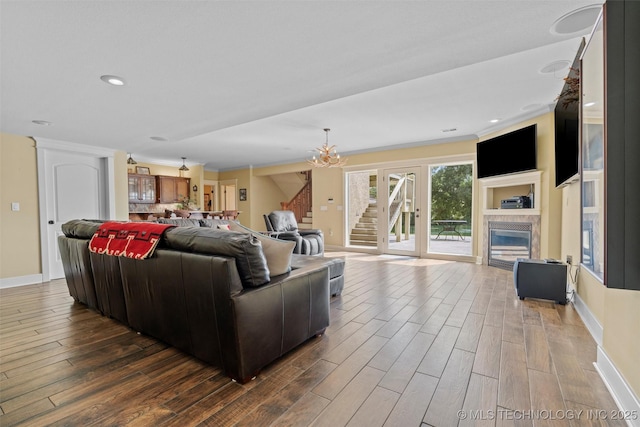 living room featuring wood-type flooring, a chandelier, and a fireplace