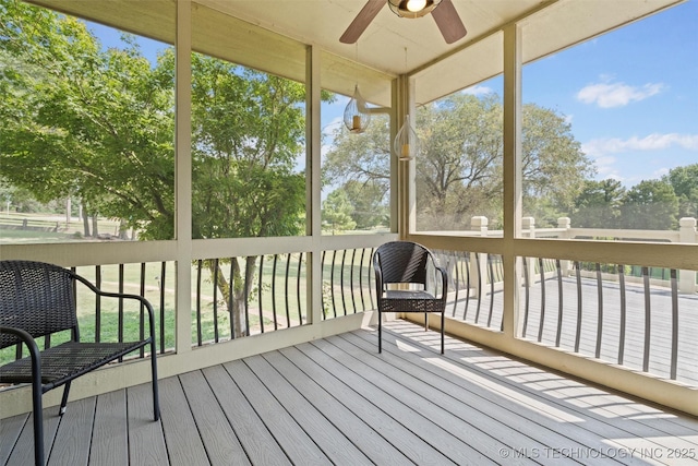 unfurnished sunroom featuring ceiling fan