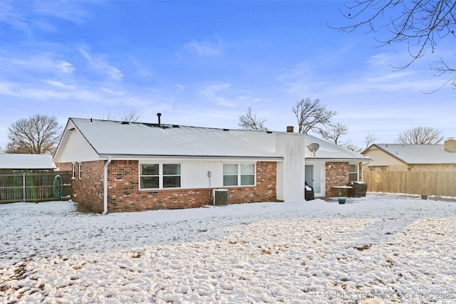 snow covered house with central air condition unit