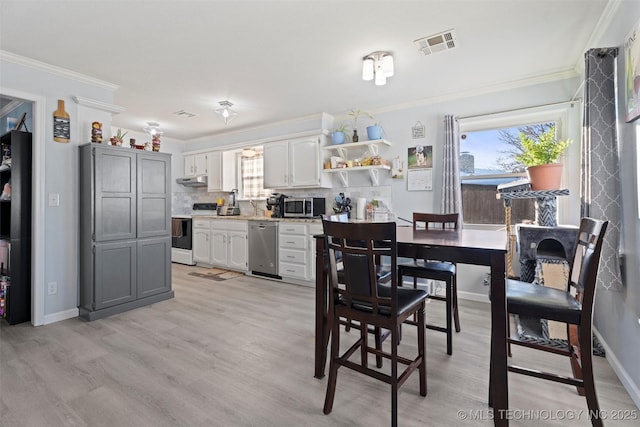 dining room featuring ornamental molding and light wood-type flooring