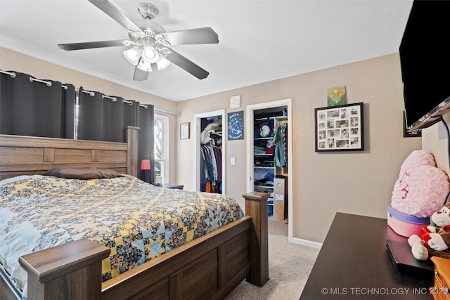 carpeted bedroom featuring a spacious closet and ceiling fan