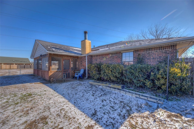 rear view of house featuring a sunroom