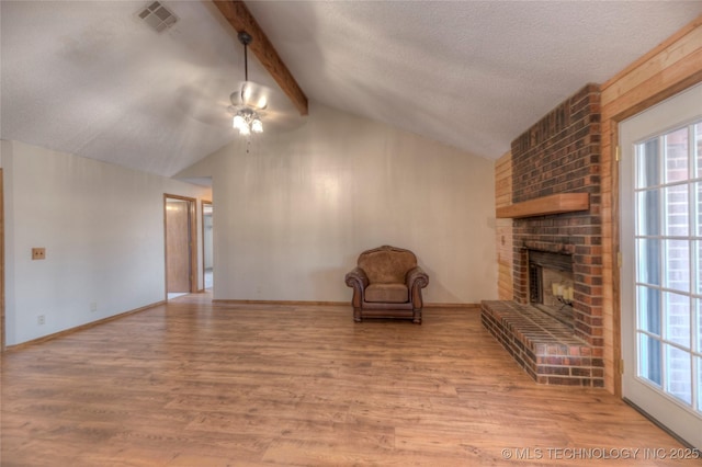 unfurnished room featuring vaulted ceiling with beams, hardwood / wood-style flooring, plenty of natural light, and a brick fireplace