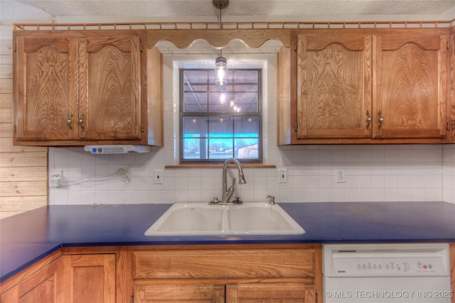 kitchen featuring white dishwasher, sink, decorative backsplash, and a textured ceiling