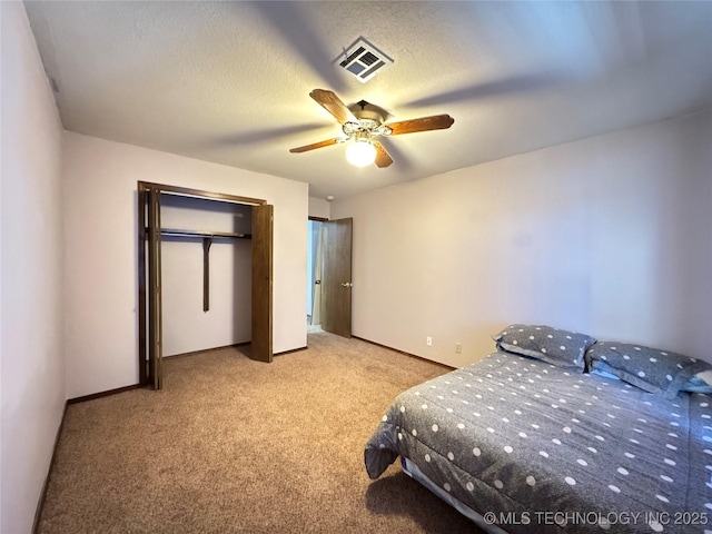 bedroom featuring ceiling fan, light colored carpet, and a textured ceiling