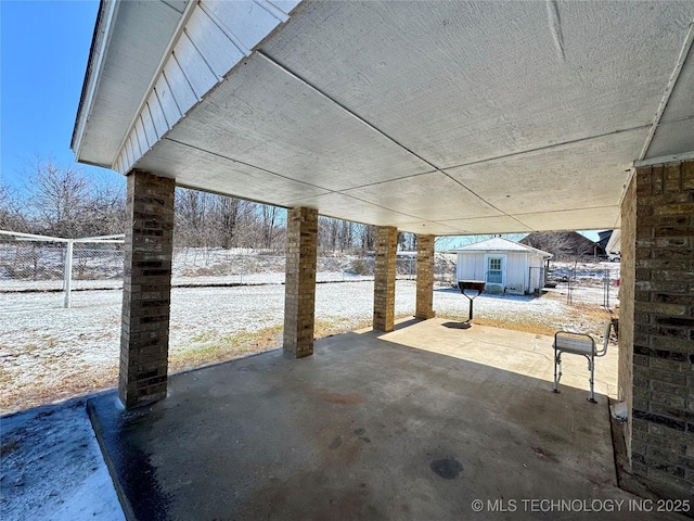 snow covered patio with an outdoor structure