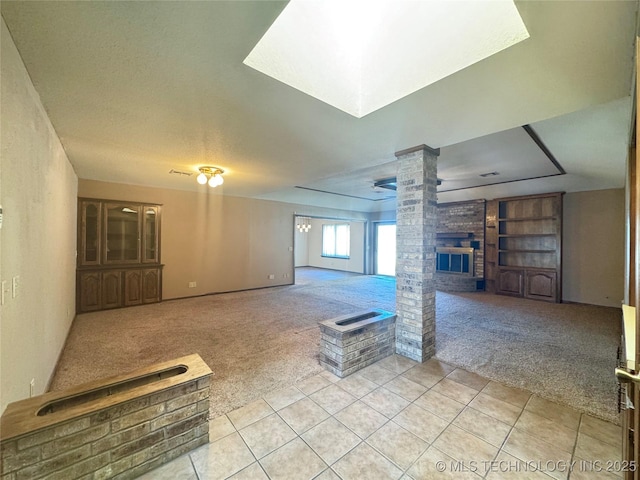 basement featuring light carpet, a fireplace, and built in shelves