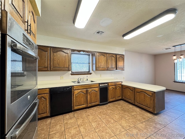 kitchen featuring pendant lighting, sink, black dishwasher, kitchen peninsula, and a textured ceiling