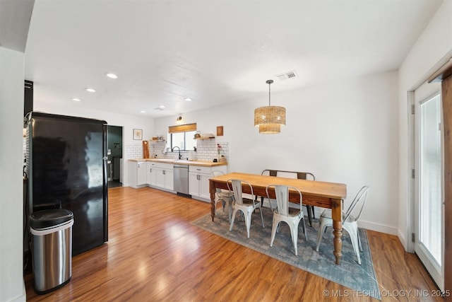 dining area featuring sink and light hardwood / wood-style floors