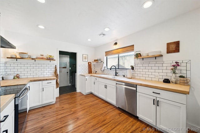 kitchen featuring white cabinetry, sink, wooden counters, and appliances with stainless steel finishes