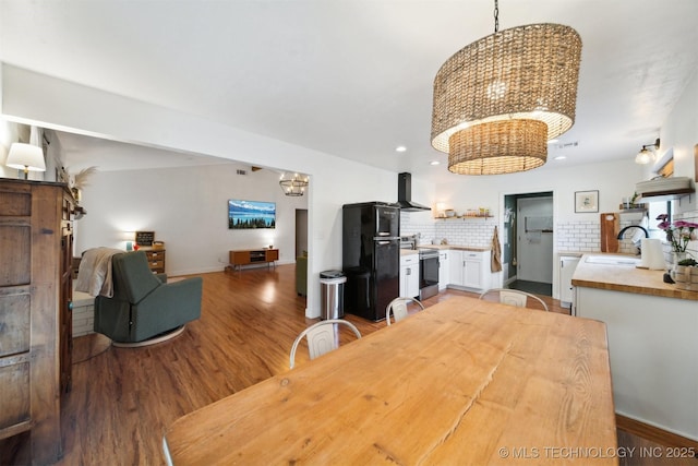 dining space featuring hardwood / wood-style flooring, sink, and an inviting chandelier