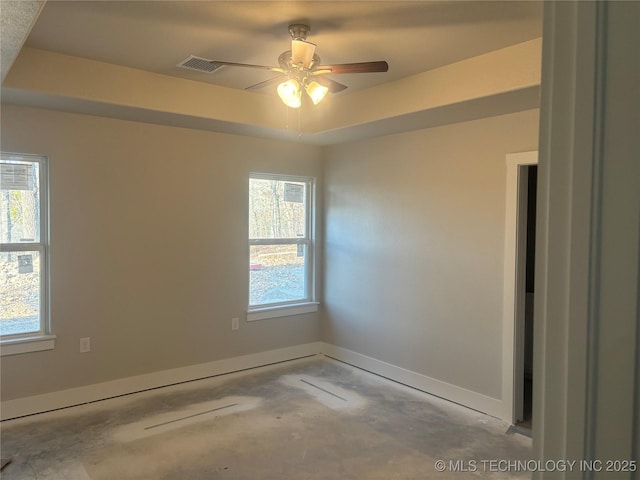 empty room with a raised ceiling and ceiling fan