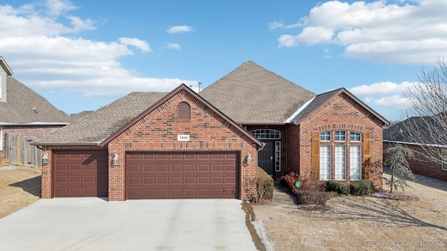 view of front of property with a garage, brick siding, roof with shingles, and driveway