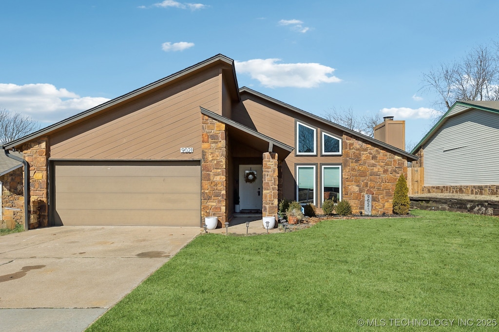 view of front of property featuring a garage and a front lawn