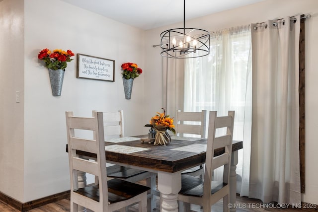 dining area with hardwood / wood-style flooring and a chandelier