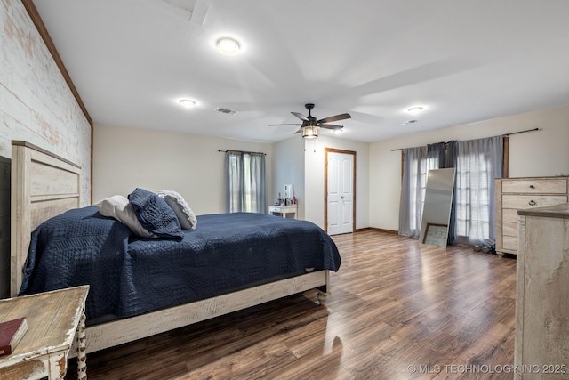 bedroom with dark hardwood / wood-style flooring, multiple windows, and ceiling fan