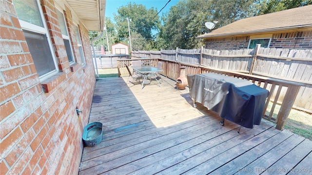 wooden terrace featuring a pool and grilling area