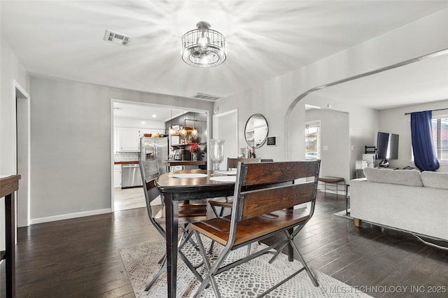 dining space with an inviting chandelier and dark hardwood / wood-style flooring