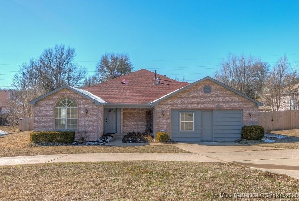 ranch-style house featuring a garage and a front yard