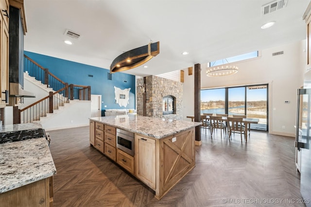kitchen featuring visible vents, baseboards, light brown cabinetry, and stainless steel appliances