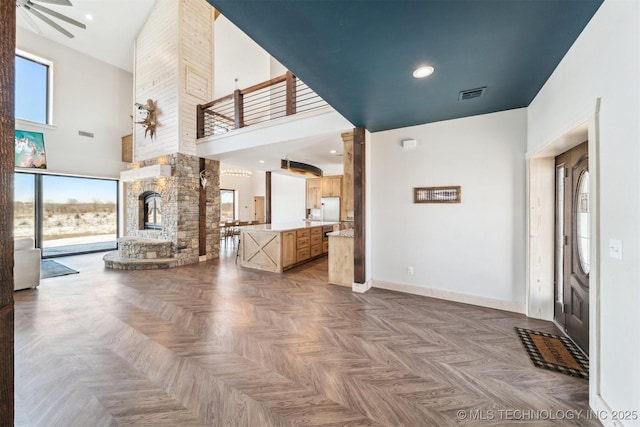 9501 S 4170th Rd, Claremore, OK 74017 - unfurnished living room featuring a towering ceiling, a fireplace, and baseboards