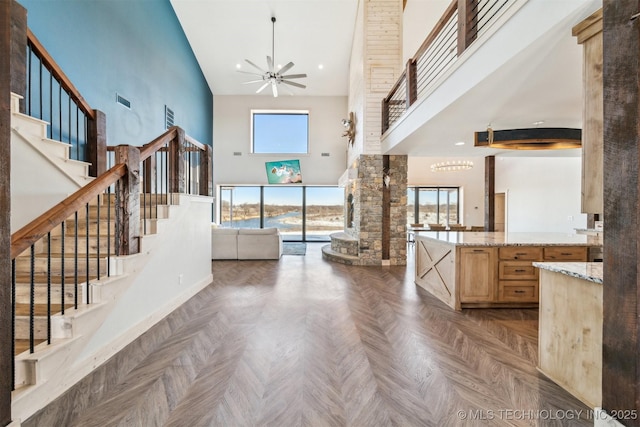 9501 S 4170th Rd, Claremore, OK 74017 - foyer entrance with a towering ceiling, stairway, a ceiling fan, and baseboards