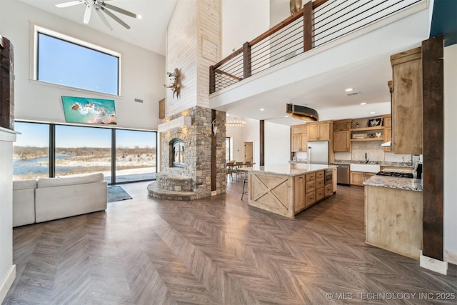 9501 S 4170th Rd, Claremore, OK 74017 - kitchen with open shelves, a towering ceiling, a sink, a ceiling fan, and stainless steel appliances