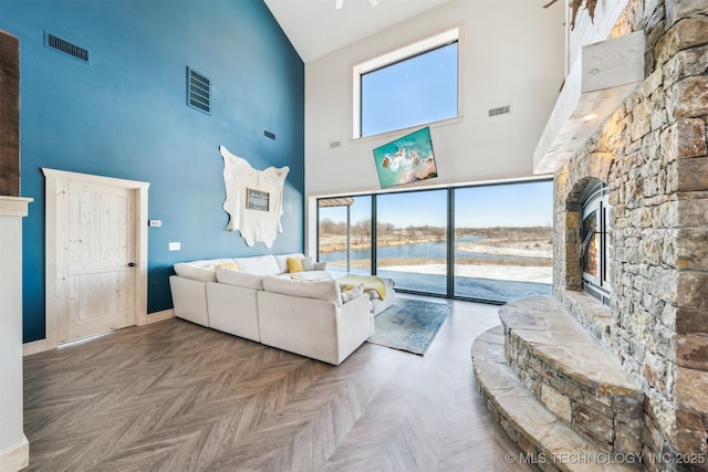 9501 S 4170th Rd, Claremore, OK 74017 - living area with high vaulted ceiling, a fireplace, a water view, and baseboards