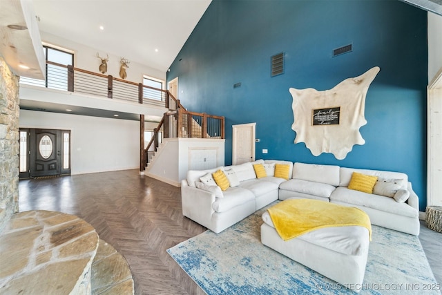 living room with visible vents, recessed lighting, stairs, and high vaulted ceiling