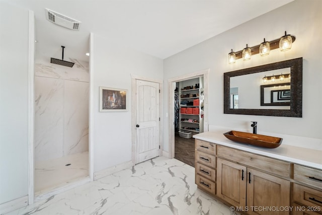 bathroom featuring visible vents, a marble finish shower, marble finish floor, and vanity