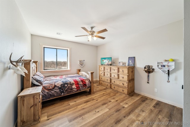 bedroom featuring baseboards, ceiling fan, visible vents, and light wood-style flooring