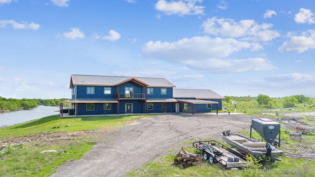 9501 S 4170th Rd, Claremore, OK 74017 - view of front of property with driveway, a metal roof, a balcony, a carport, and board and batten siding