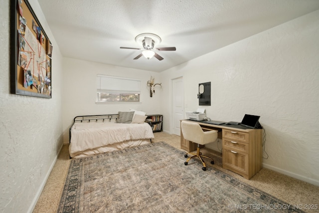 carpeted bedroom featuring ceiling fan and a textured ceiling