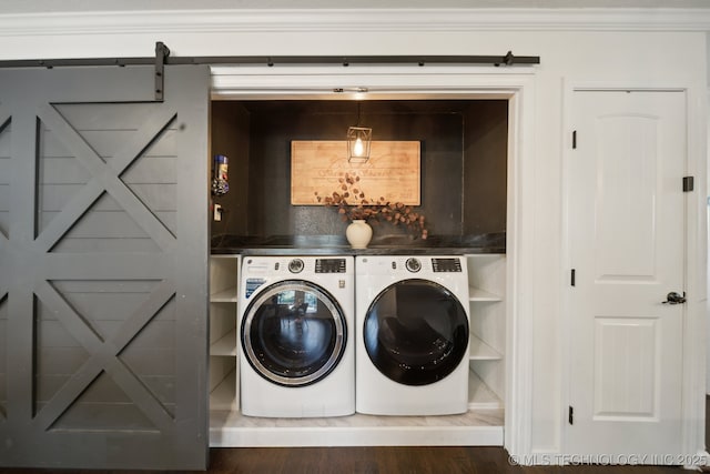 washroom with a barn door, crown molding, separate washer and dryer, and dark hardwood / wood-style floors