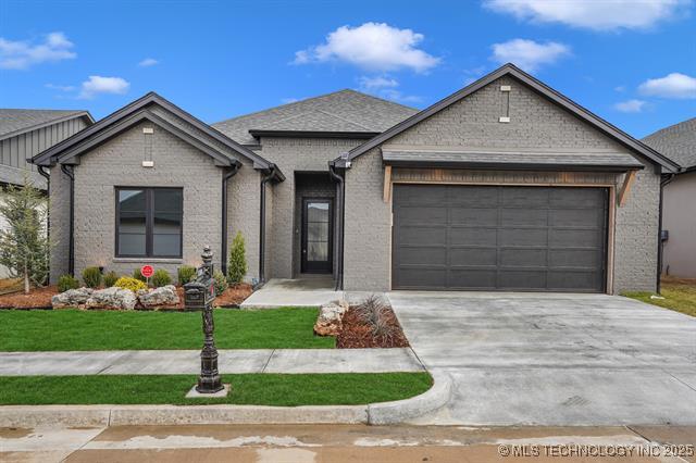 view of front facade featuring a front lawn, brick siding, concrete driveway, and an attached garage