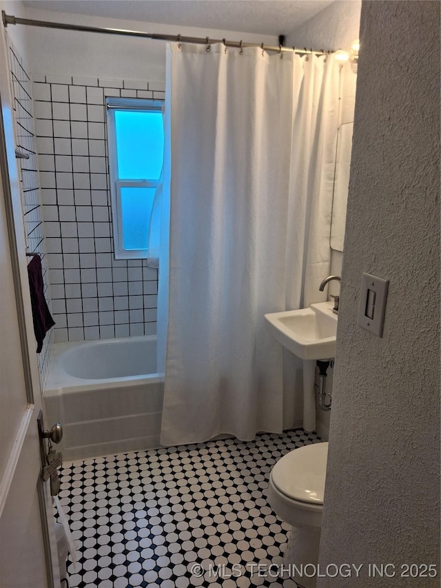 bathroom with shower / bathtub combination with curtain and toilet