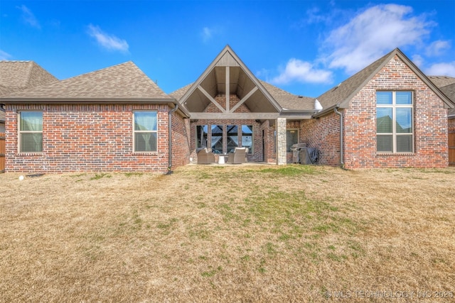 rear view of property featuring a lawn and a patio